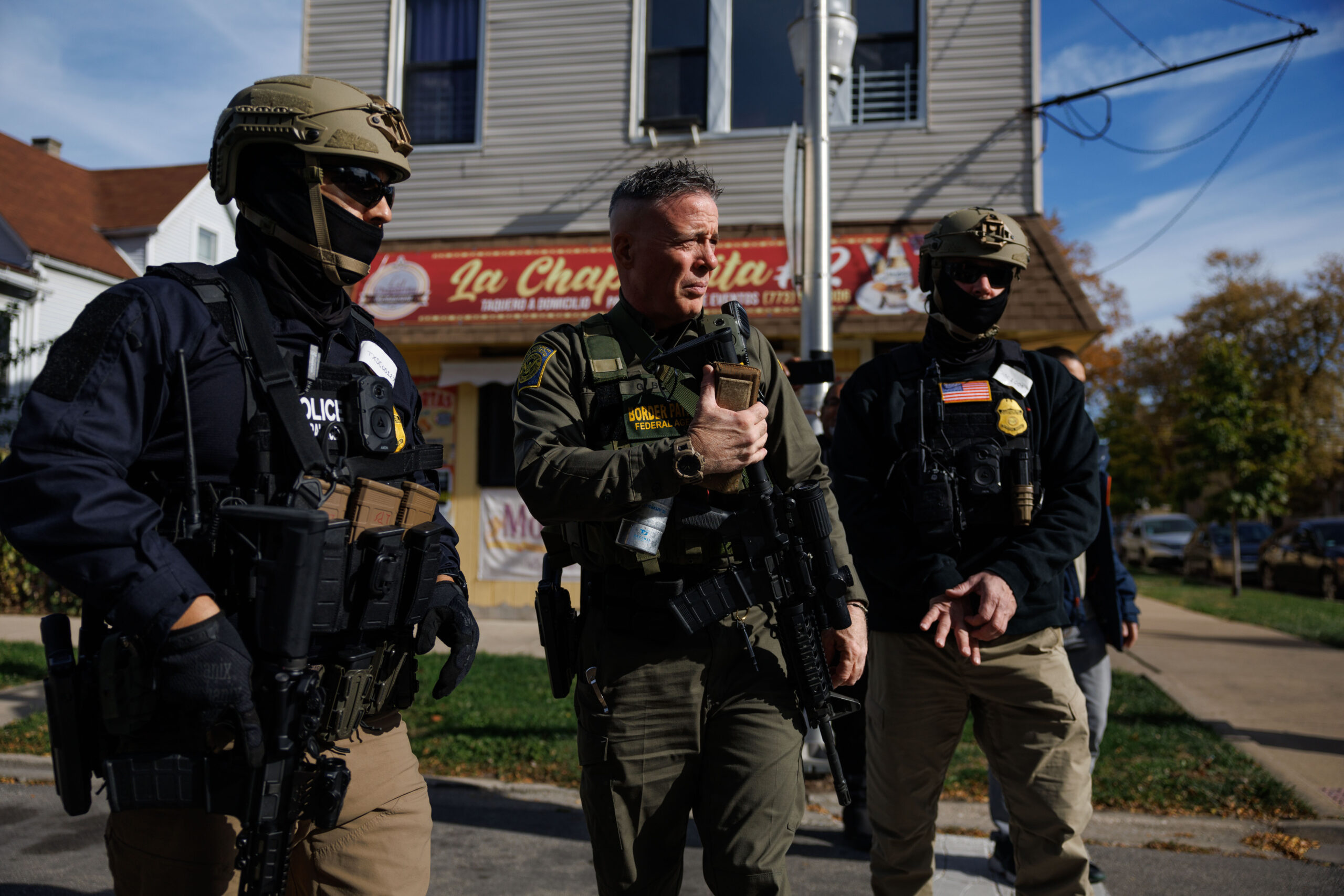 Border Patrol Cmdr. Gregory Bovino, center, walks with other agents...