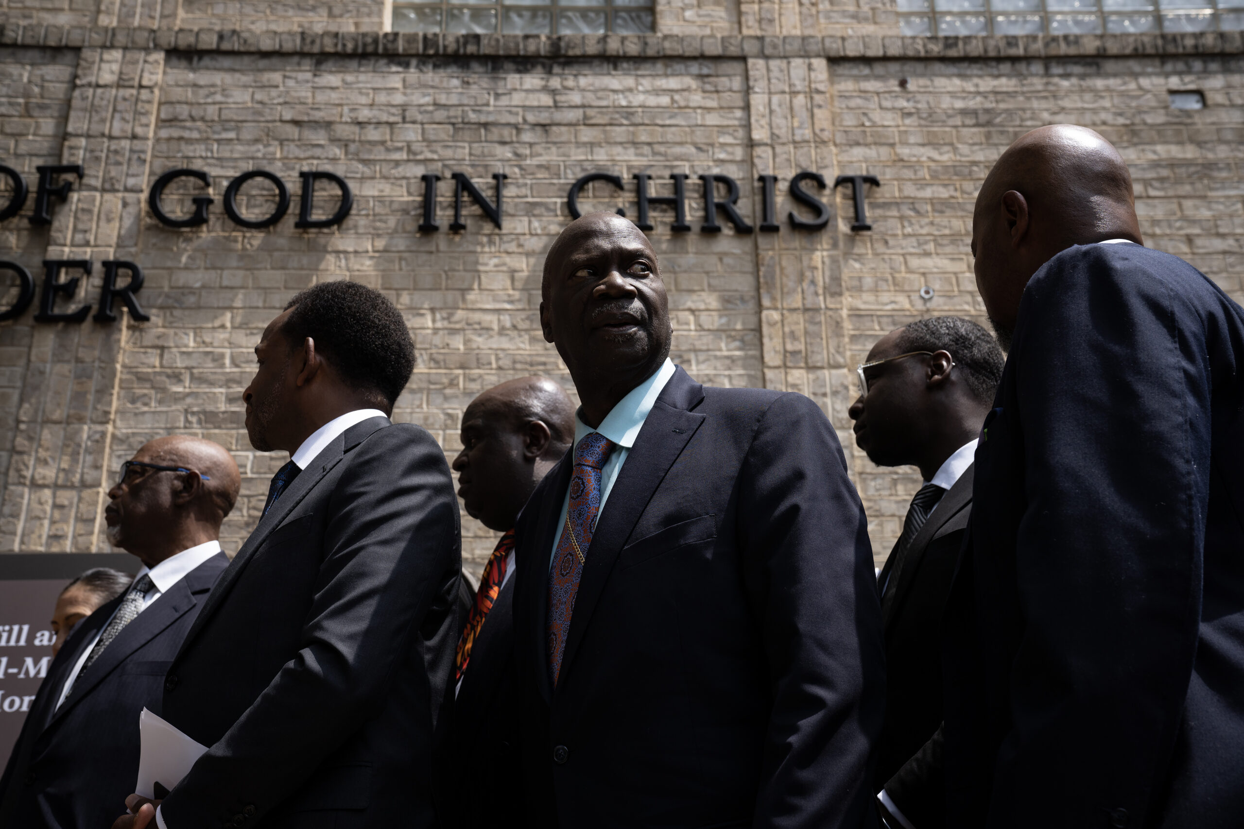 Clergy watch the unveiling of of temporary signage for the...