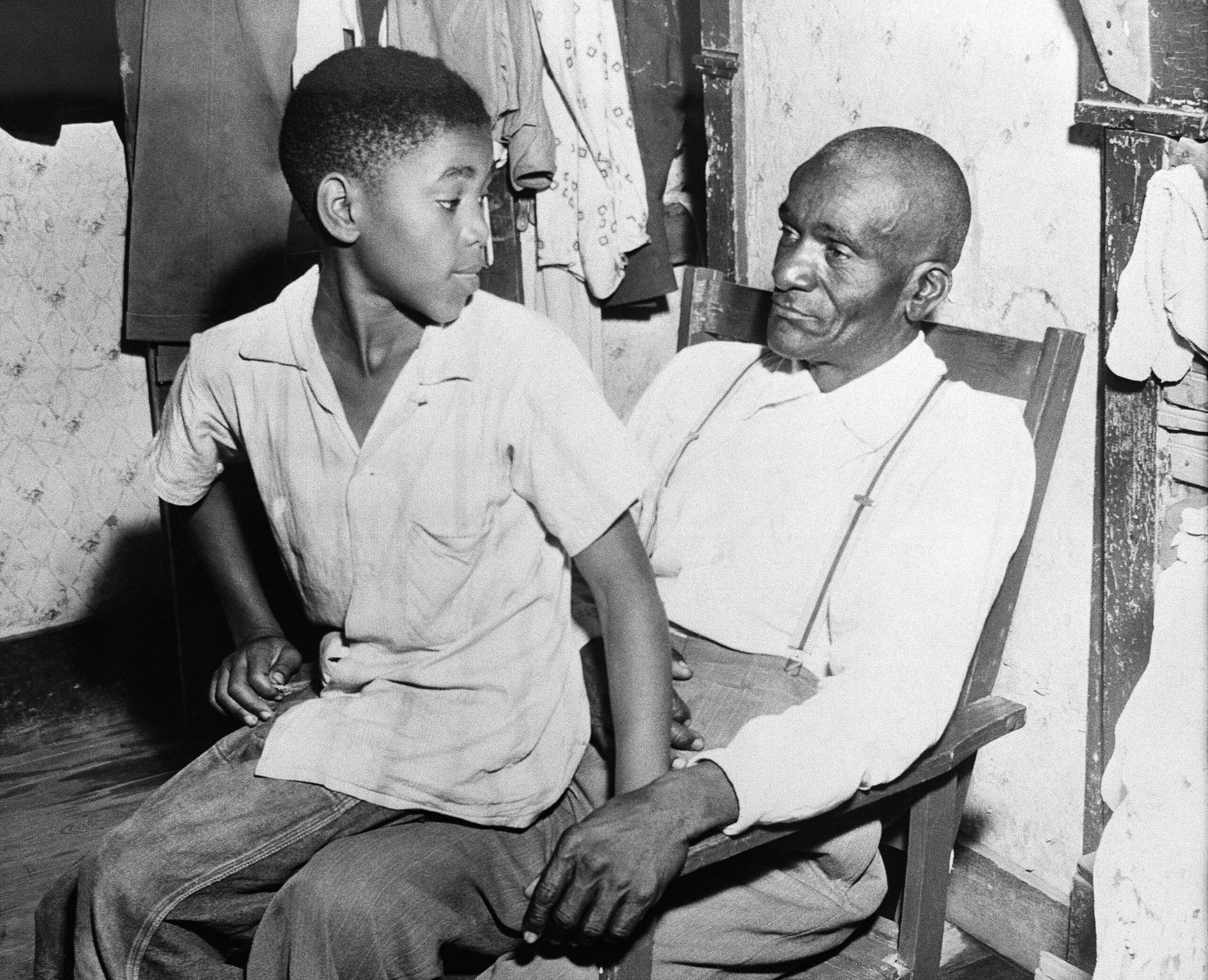 Mose Wright, right, and his son, Simeon, sit in their...
